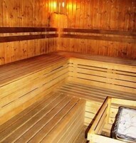 Una sauna con bancos de madera y un banco con toalla.