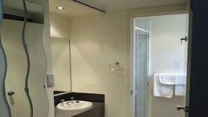 Un bagno con lavandino, specchio e doccia.