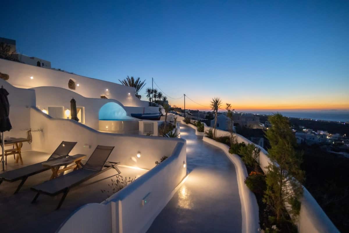 Un edificio moderno con techo curvo, asientos al aire libre y vistas a la costa.