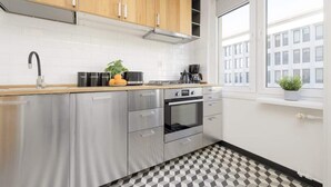Una cocina moderna con electrodomésticos de acero inoxidable, armarios de madera y suelo a cuadros.