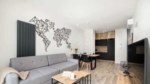A modern living room with a grey sofa, a wooden coffee table, and a world map wall art.
