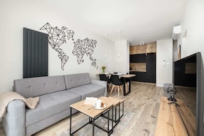 A modern living room with a grey sofa, a wooden coffee table, and a world map wall art.