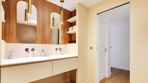 A modern bathroom with a wooden vanity, a large mirror, and pendant lights. - A Breathtaking 3-BR/3BA in Trocadéro - Tour Eiffel (Paris)