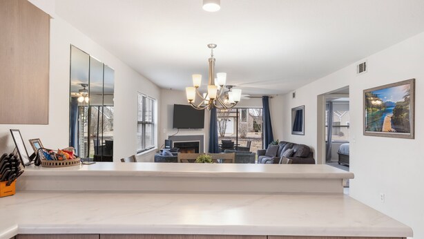 A modern kitchen with a large island, a chandelier, and a dining area with a sofa and table. - 2-bedroom, 2-bathroom in the heart of Branson, MO. Walk-in Unit.




 (Branson)