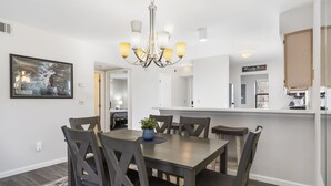 A dining area with a wooden table and chairs, a chandelier, and a painting on the wall. - 2-bedroom, 2-bathroom in the heart of Branson, MO. Walk-in Unit.




 (Branson)