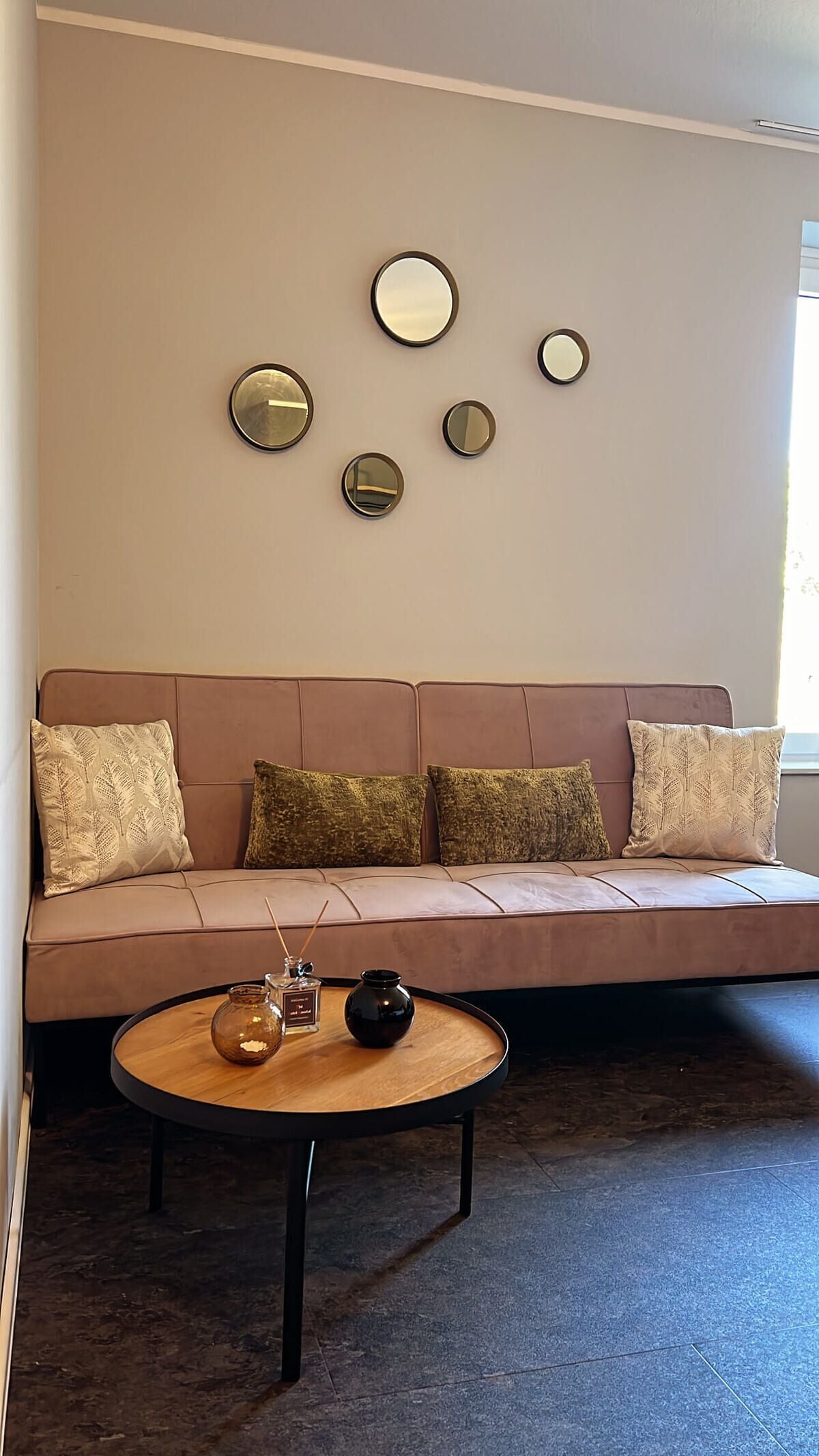 Ein Wohnzimmer mit einer Couch, einem Couchtisch und Wandspiegeln.