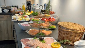 A buffet with various meats, cheeses, and fruits.