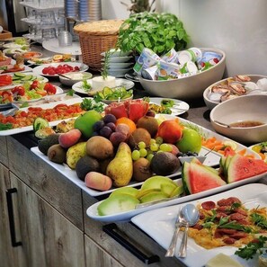 A buffet table with various fruits, vegetables, and dairy products. - Motel Hasetal (Loningen)