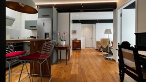 Una cocina moderna con comedor, piso de madera y vista al salón.