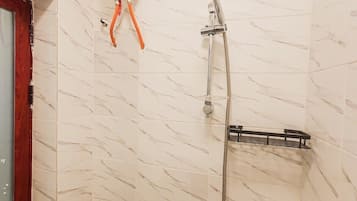A shower with a handheld showerhead, a handheld shower attachment, and a wall-mounted faucet.