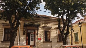 Un bâtiment à la façade traditionnelle, avec une porte et un banc à l’extérieur.