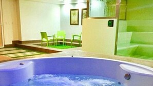 Un bain à remous avec vue sur un espace extérieur verdoyant et une chaise.