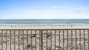 A beach with a railing in the foreground and the ocean in the background. - GD 410: Shimmering Sea - Sandy Toes, Cozy Condo, The Perfect Pairing! (Fort Walton Beach)