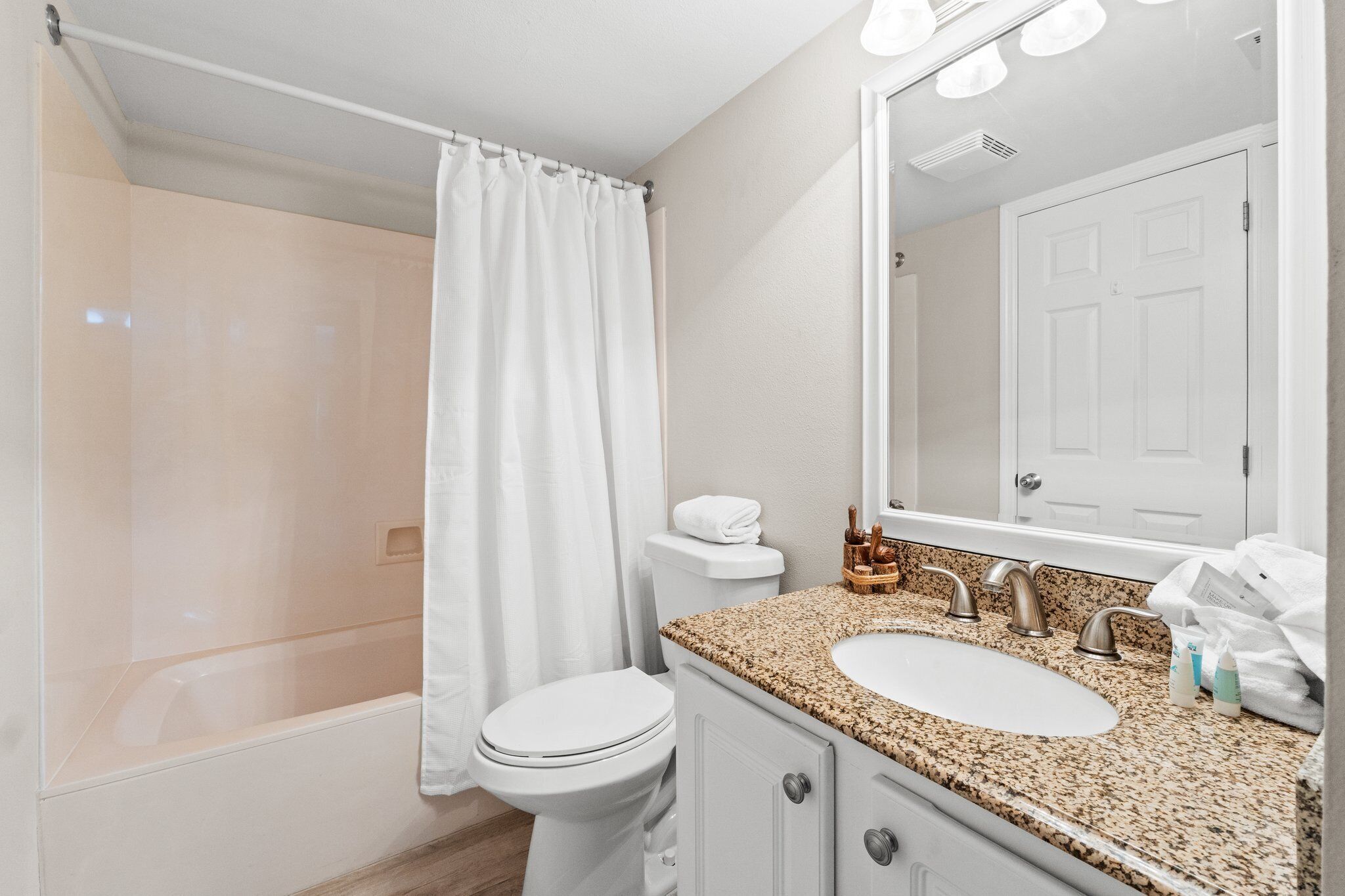 Un baño con ducha, inodoro, lavabo y espejo.