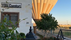 A villa named "Villa Comfort" with a hot air balloon in the background. - Cappadocia Villa Comfort (Nevsehir)