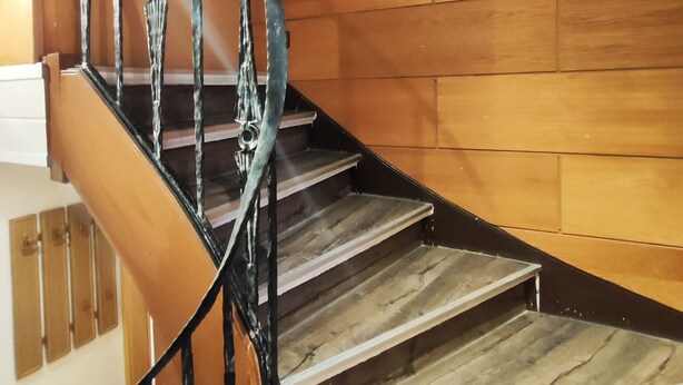A spiral staircase with wooden steps and black metal railings. - Gemütliche Ferienwohnung Belvie in Pohl-göns (Butzbach)