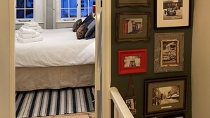 Un dormitorio con cama, almohadas y vistas al exterior por una ventana.