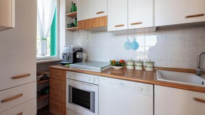 A modern kitchen with white cabinets, wooden countertops, a built-in oven, and a dishwasher. - Villa Giorgisa Casale pool sea view (Ugento)