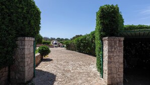 A stone pathway leading to a building with a covered entrance. - Villa Giorgisa Casale pool sea view (Ugento)