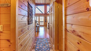 A wooden hallway with a 'Welcome' sign, a patterned floor, and a view of the outside. - Gorgeous Blue Ridge Mountain Retreat: Deck + View! (Blue Ridge)