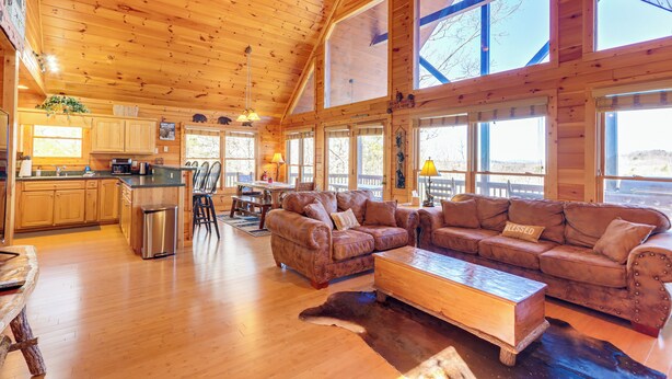A spacious wooden cabin with a large living area, a kitchen, and a dining area. - Gorgeous Blue Ridge Mountain Retreat: Deck + View! (Blue Ridge)