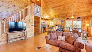 A wooden cabin interior with a living room, kitchen, and dining area. - Gorgeous Blue Ridge Mountain Retreat: Deck + View! (Blue Ridge)