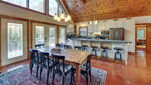 A spacious kitchen with wooden beams, large windows, and a central island with stools. - Cabin w/ Hot Tub and Wifi: 4 Mi to Snowshoe Resort (Cass)