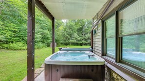 A hot tub under a covered patio with a view of a green landscape. - Cabin w/ Hot Tub and Wifi: 4 Mi to Snowshoe Resort (Cass)