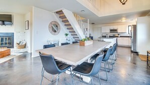 A spacious kitchen with a long island, modern appliances, and a staircase leading to an upper level. - Deck + Kayaks: Grand Lake of the Cherokees Home (Afton)