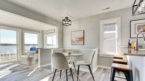 A modern kitchen with a dining area, large windows, and a view of the outdoors. - Waterfront Buckeye Lake Home w/ Deck & Dock! (Buckeye Lake)