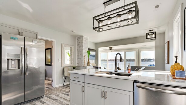 A modern kitchen with stainless steel appliances, a large island, and a view to the outside. - Waterfront Buckeye Lake Home w/ Deck & Dock! (Buckeye Lake)
