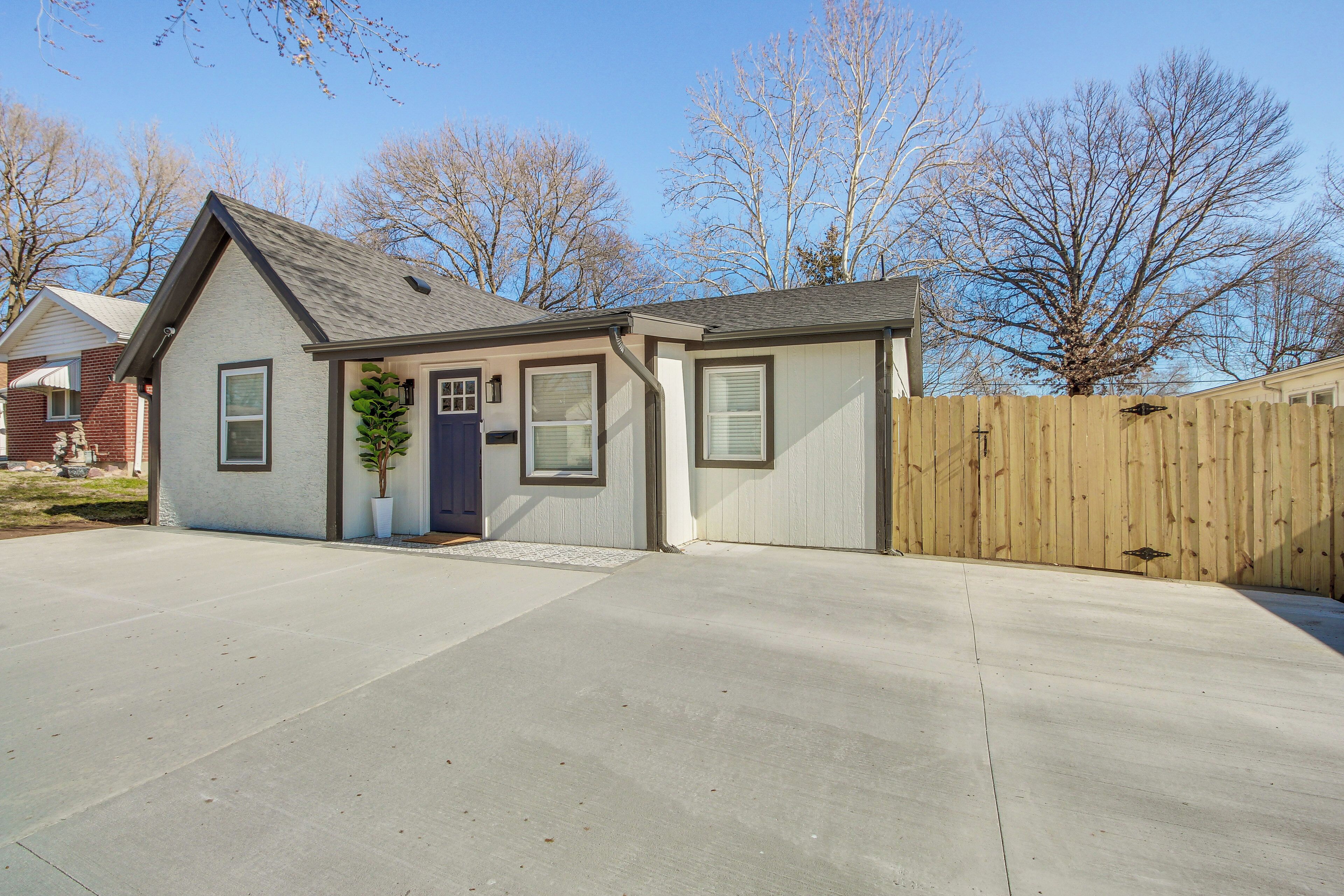 A single-story house with a front porch, a garage, and a wooden fence.