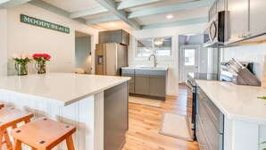 A modern kitchen with a central island, grey cabinets, and a sign reading "MOODY BEACH". - Beautiful Wells Cottage: Steps to Moody Beach! (Wells)