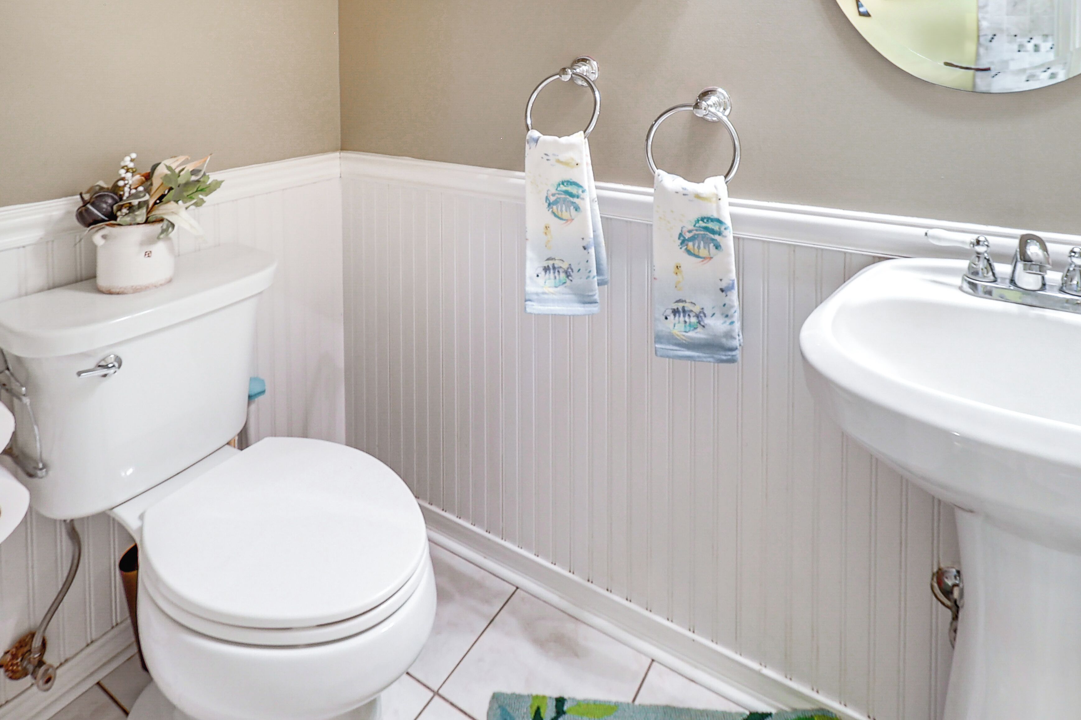 A bathroom with a toilet, sink, and towel racks.