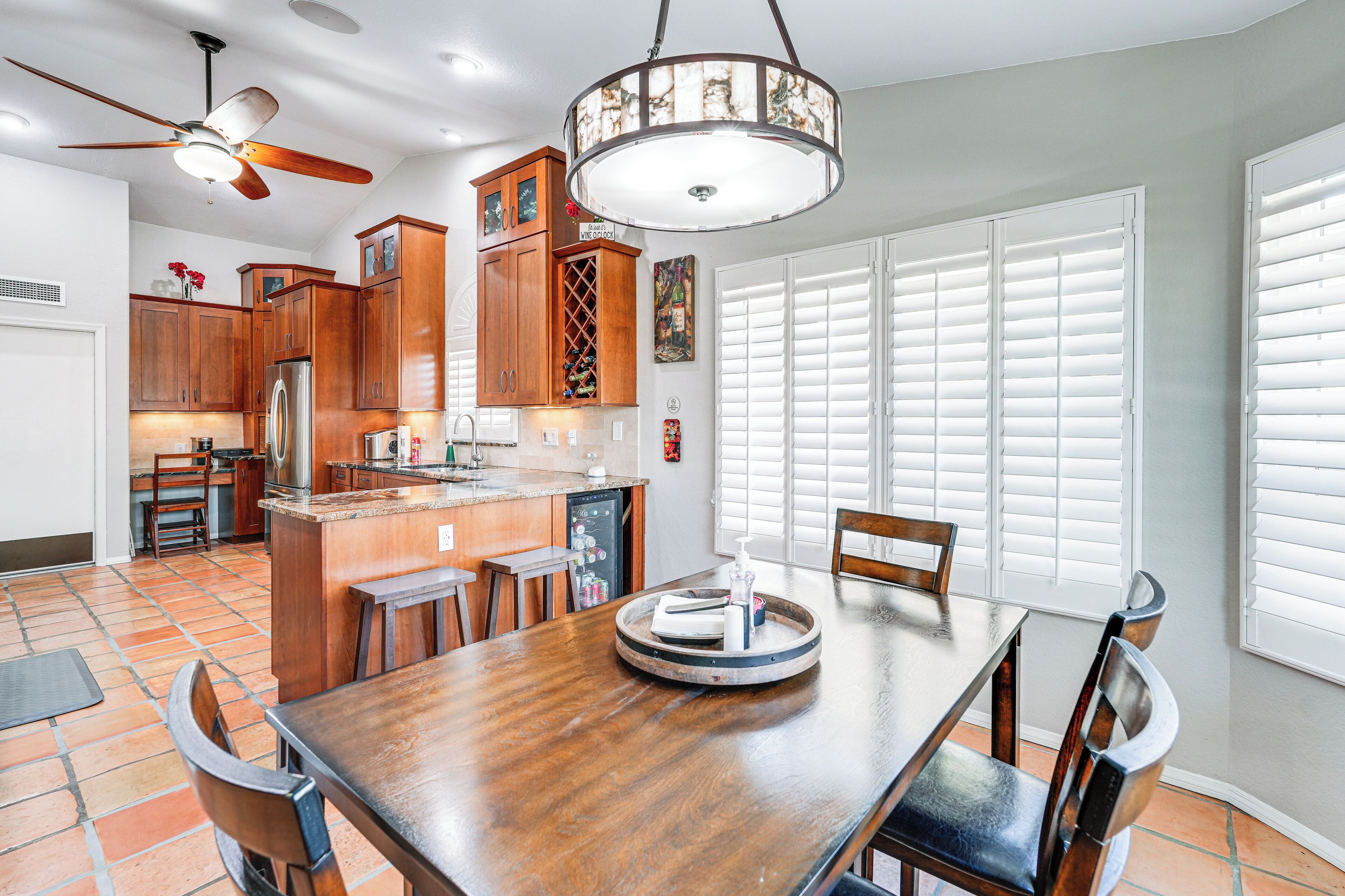 A spacious kitchen with wooden cabinets, a central island, and a dining area with a wooden table and chairs.