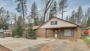 A single-story house with a garage, a front yard, and a basketball hoop. - Charming Lakehead Cabin: Walk to Shasta Lake! (Lakehead)