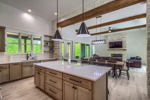 A spacious kitchen with a large island, wooden cabinets, and pendant lighting. - Cl 2849 River Escape At Horseshoe Falls 4 Bedroom Home by RedAwning (Canyon Lake)