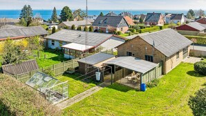 Ein Wohngebiet mit Häusern, einem Gewächshaus und Blick auf das Meer.