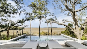 An infinity pool with lounge chairs and a wooden deck overlooking a natural landscape. - Personal Sanctuary, comfort and luxury at every turn (Kiawah Island)