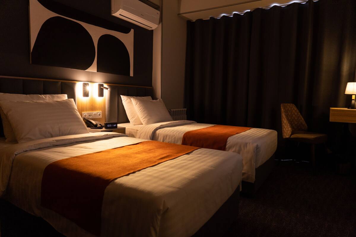 Una habitación de hotel con dos camas, un escritorio y una silla.