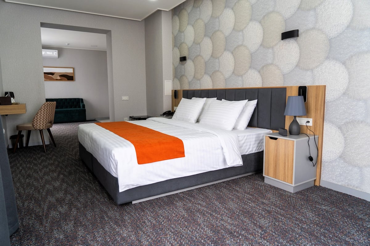 Una habitación de hotel moderna con una cama grande, un escritorio y una silla.