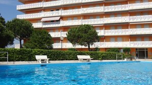 Un hôtel doté d’une piscine, de nombreux balcons et offrant une vue sur un ciel d’un bleu éclatant.