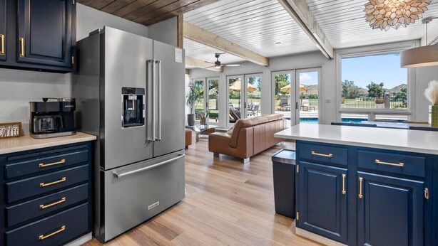 A modern kitchen with dark blue cabinets, stainless steel appliances, and a wooden ceiling. - 6BR Luxury Phoenix Home w Pool, Hot Tub, Games (Phoenix)