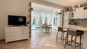 Una cocina amplia con comedor, televisor y vistas al exterior.
