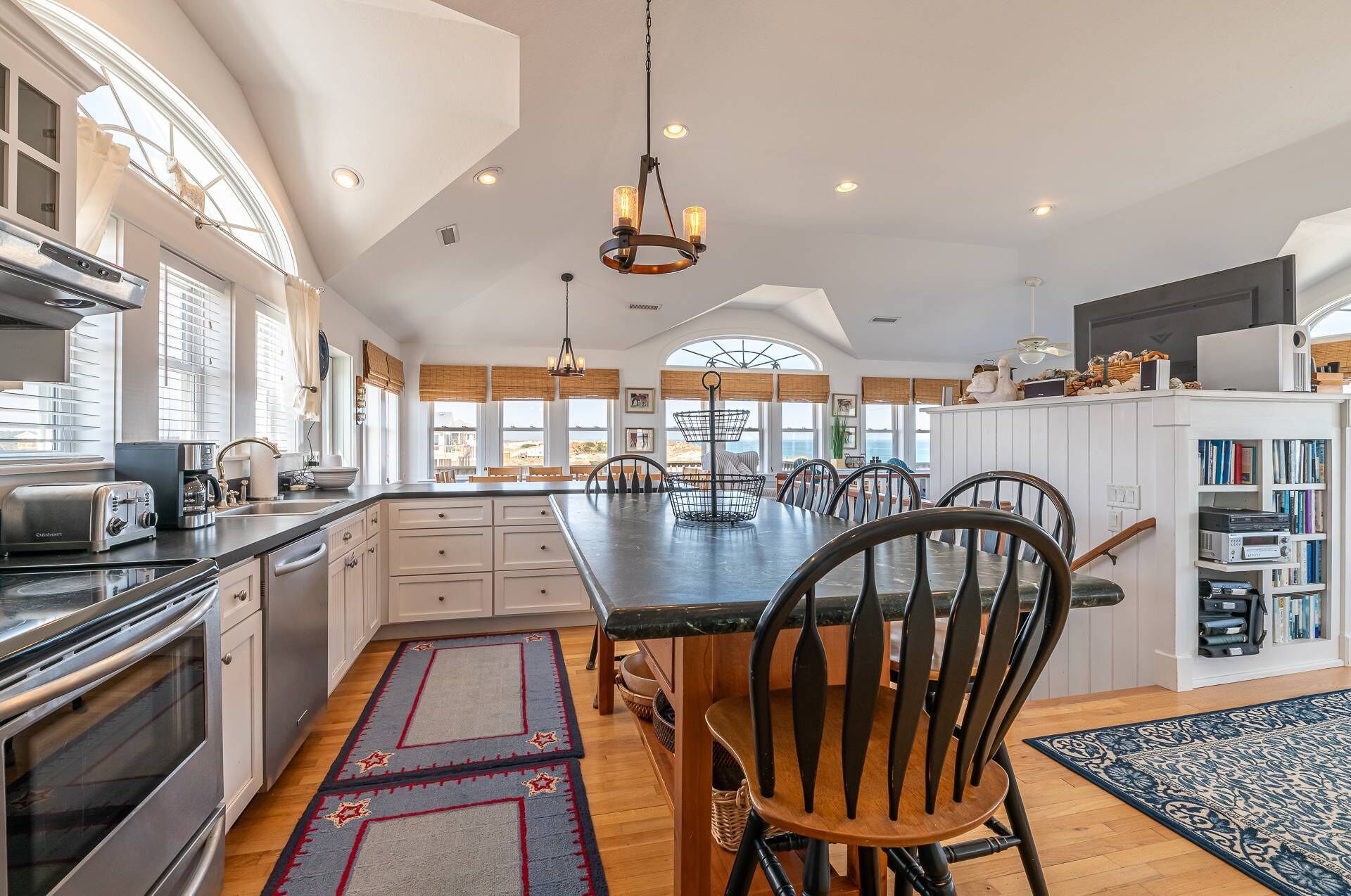 A spacious kitchen with a large island, modern appliances, and ample natural light from large windows.