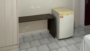 A room with a ceiling fan, a mounted TV, a small refrigerator, and tiled flooring. - Hotel Parati Arapongas (Arapongas)
