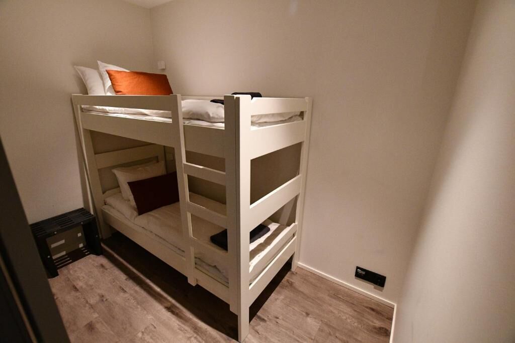 A bunk bed with storage drawers and a mattress on the lower bunk.