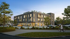 Un hôtel moderne doté d’un toit plat, de grandes fenêtres et d’un jardin bien entretenu.