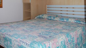 Un dormitorio con cama, armario de madera y ventana.
