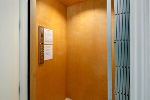 An elevator interior with a control panel and informational signs. - 6 Bedroom | 7 King Beds | Elevator | Beachfront (Navarre)